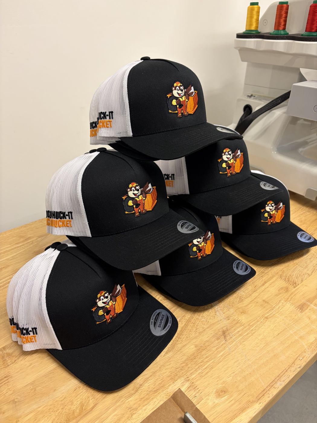 Black and white trucker hats with a full-color mascot logo