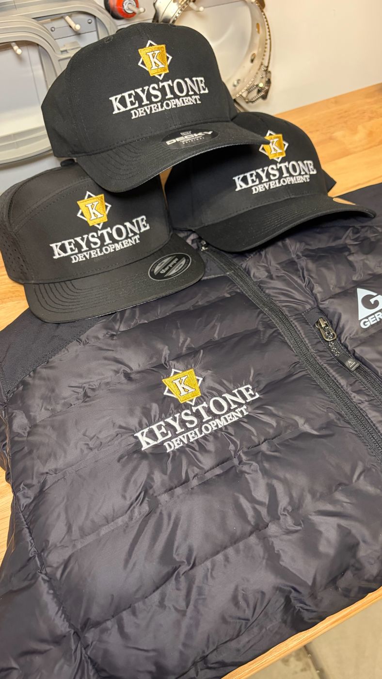 Black caps and puffer jacket with an embroidered company logo