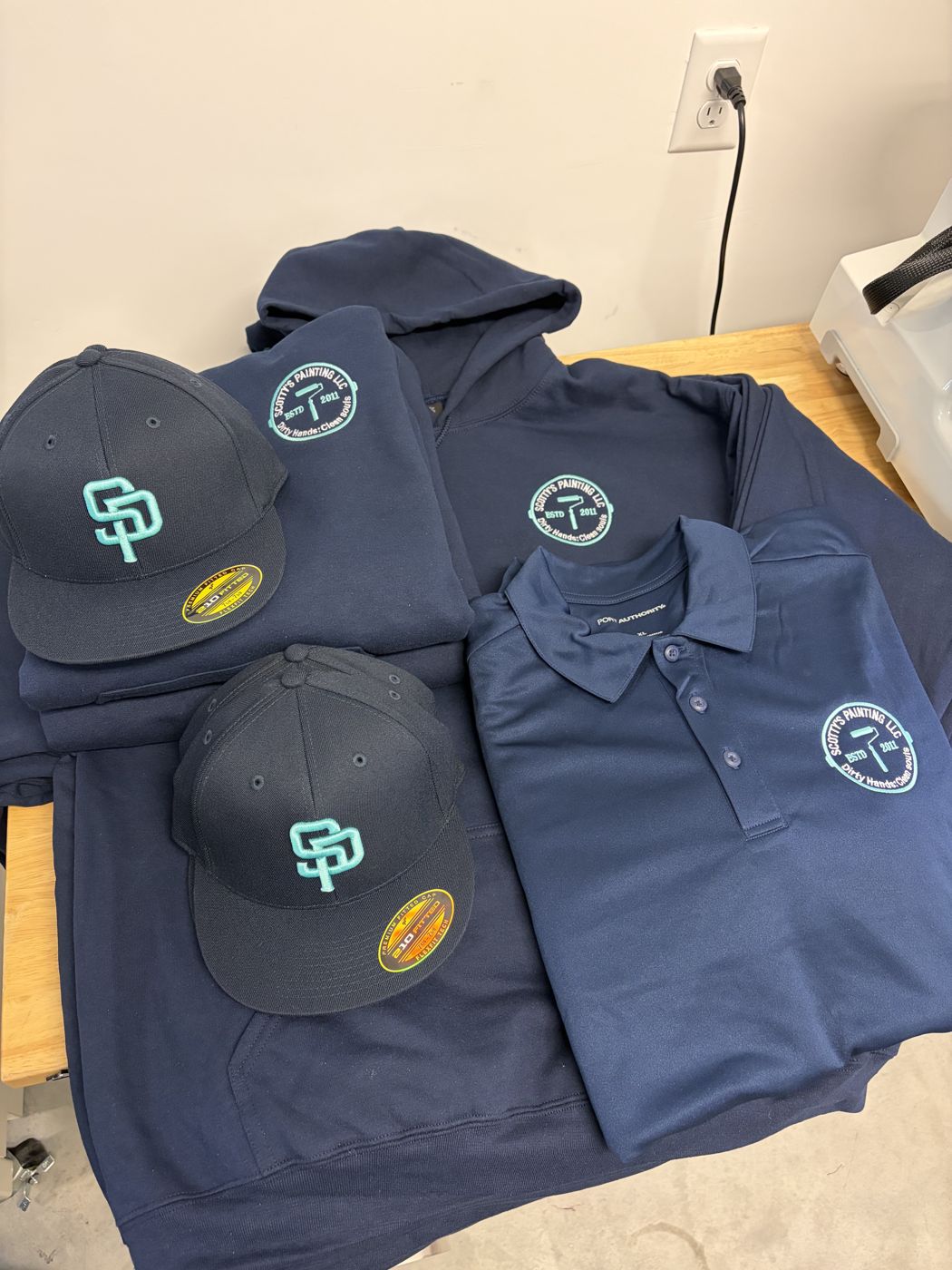 Navy caps, hoodies and polo with a matching painting company logo