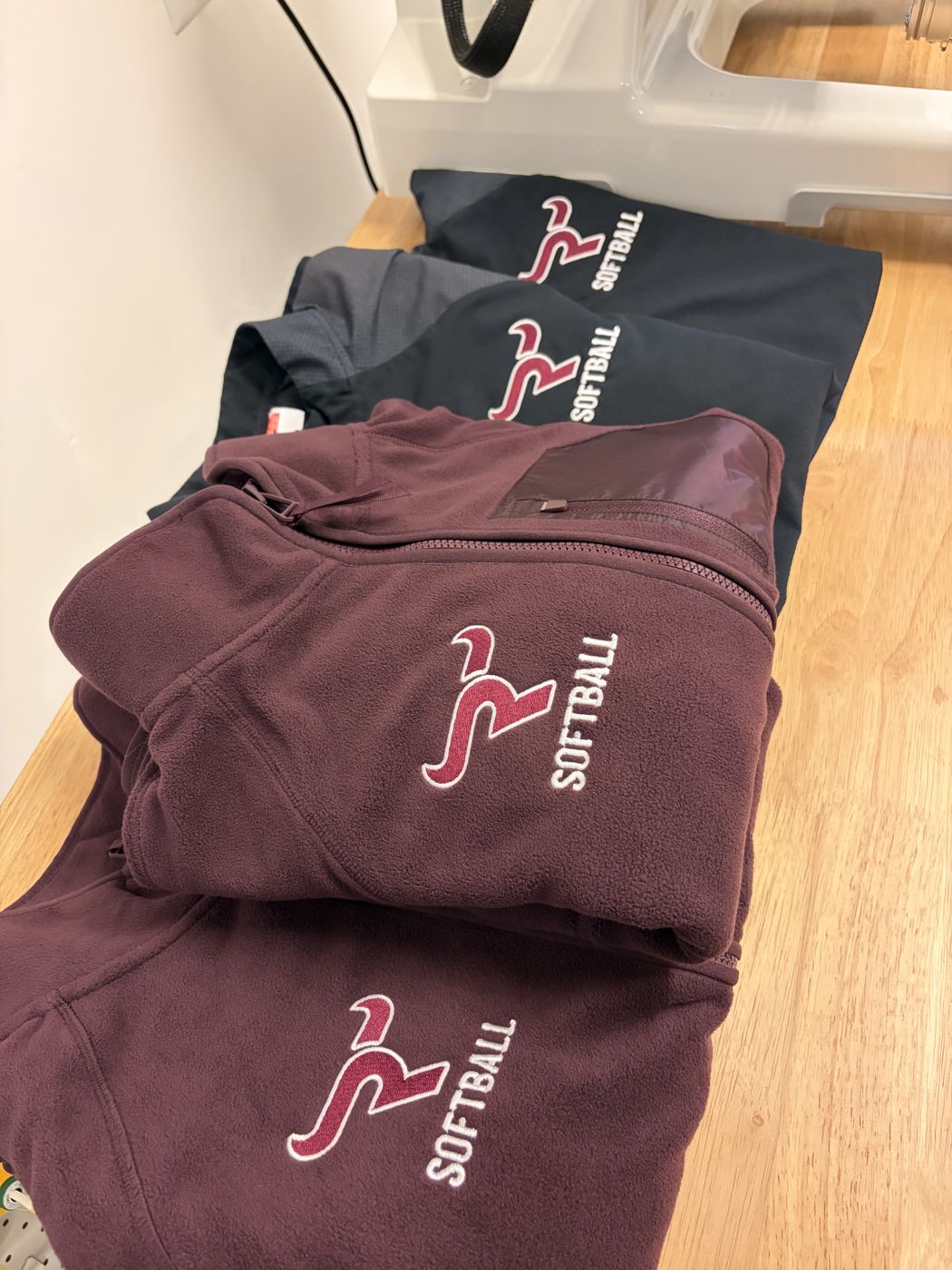 Maroon and navy fleeces with matching softball logos